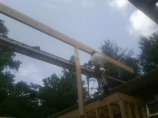 Carpenter setting a ridge beam over a new addition frame — Ice Dam Removal by Roofing Brothers in Laredo