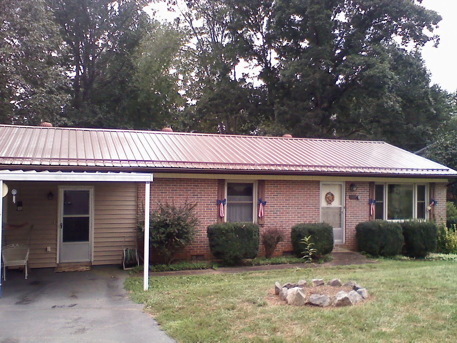 Bronze metal roof and carport on a brick ranch home — Roof Repair work by our crew in Laredo