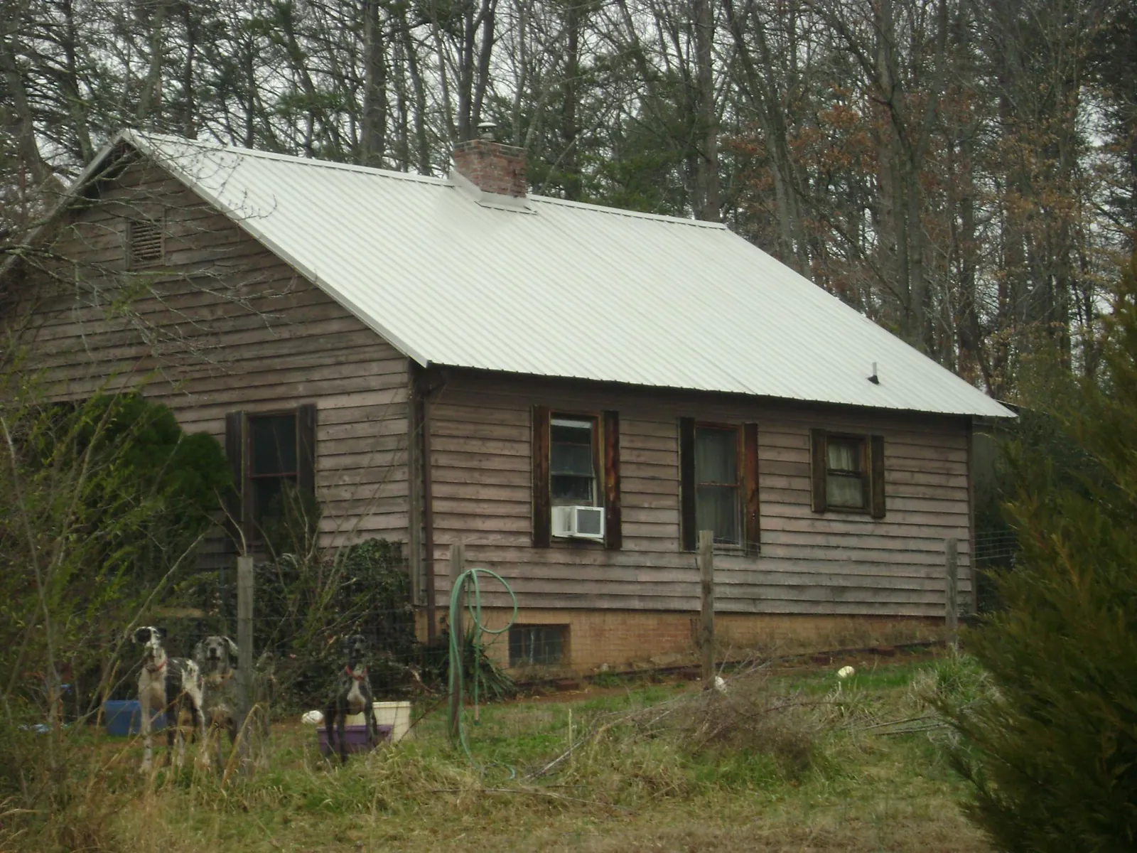 White metal roof on an old wood sided farmhouse, from a Metal Roof Installation job in Laredo